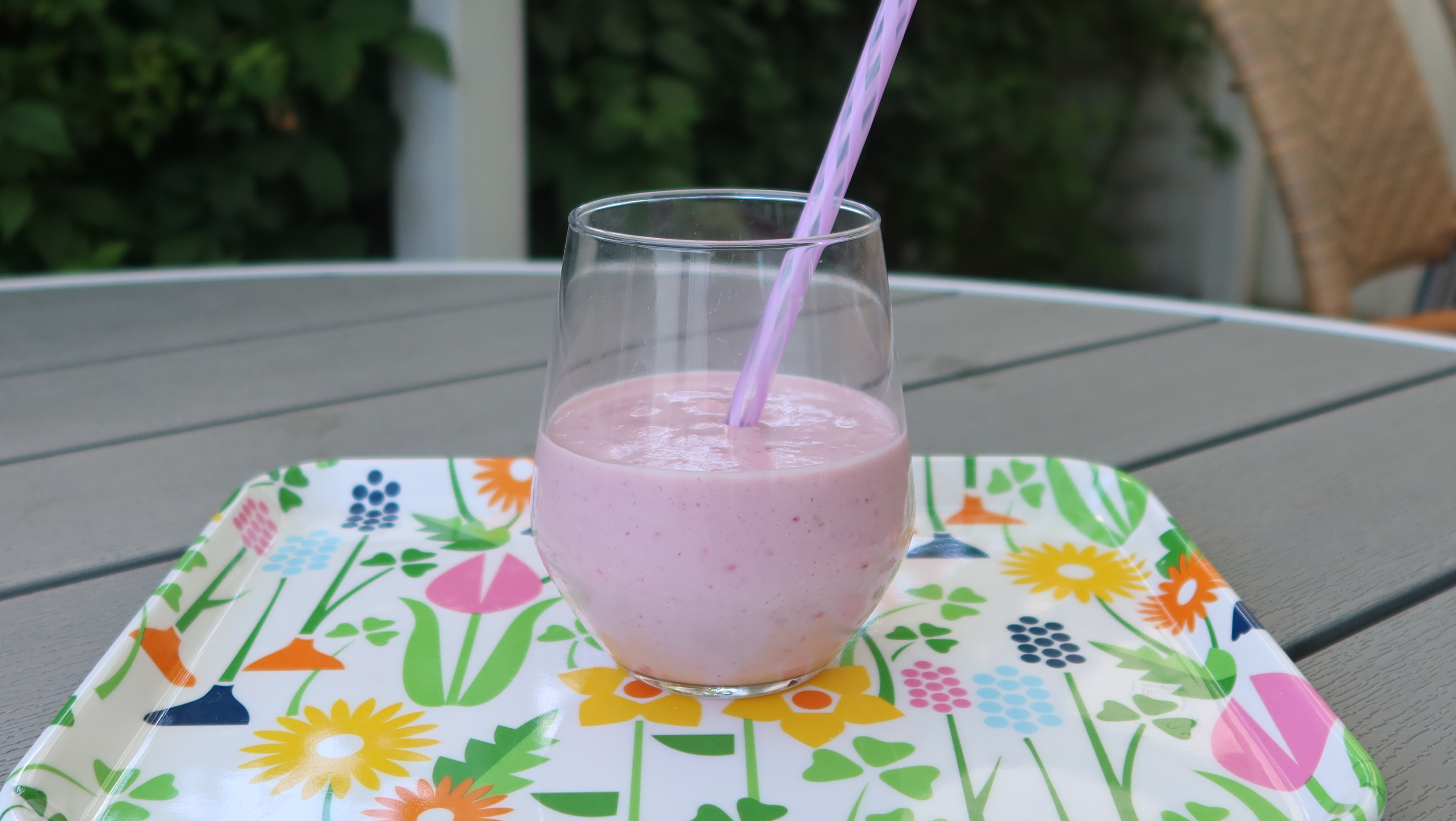 En rosa smoothie i ett genomskinligt glas