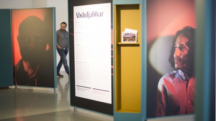 Utställningsskärmar med stora porträttbilder och text.