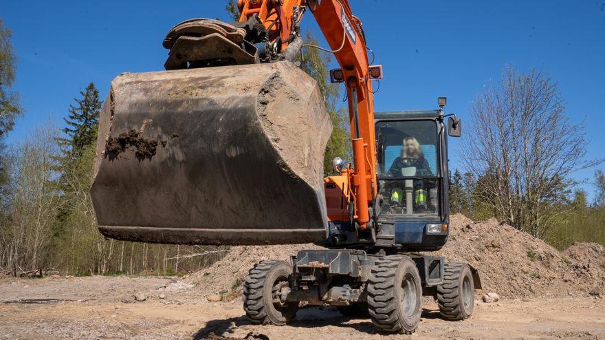 Grävmaskin med skopan i fokus