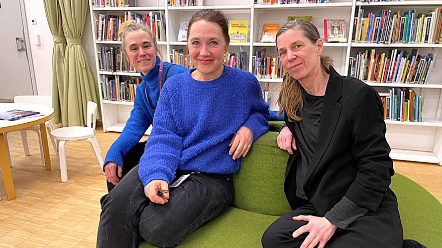 Åsa Abrahamsson, Annika Malmborg och Erika Magnusson sitter på en rund grön sittmöbel i biblioteksrummet. Alla tre tittar rakt in i kameran och ler.