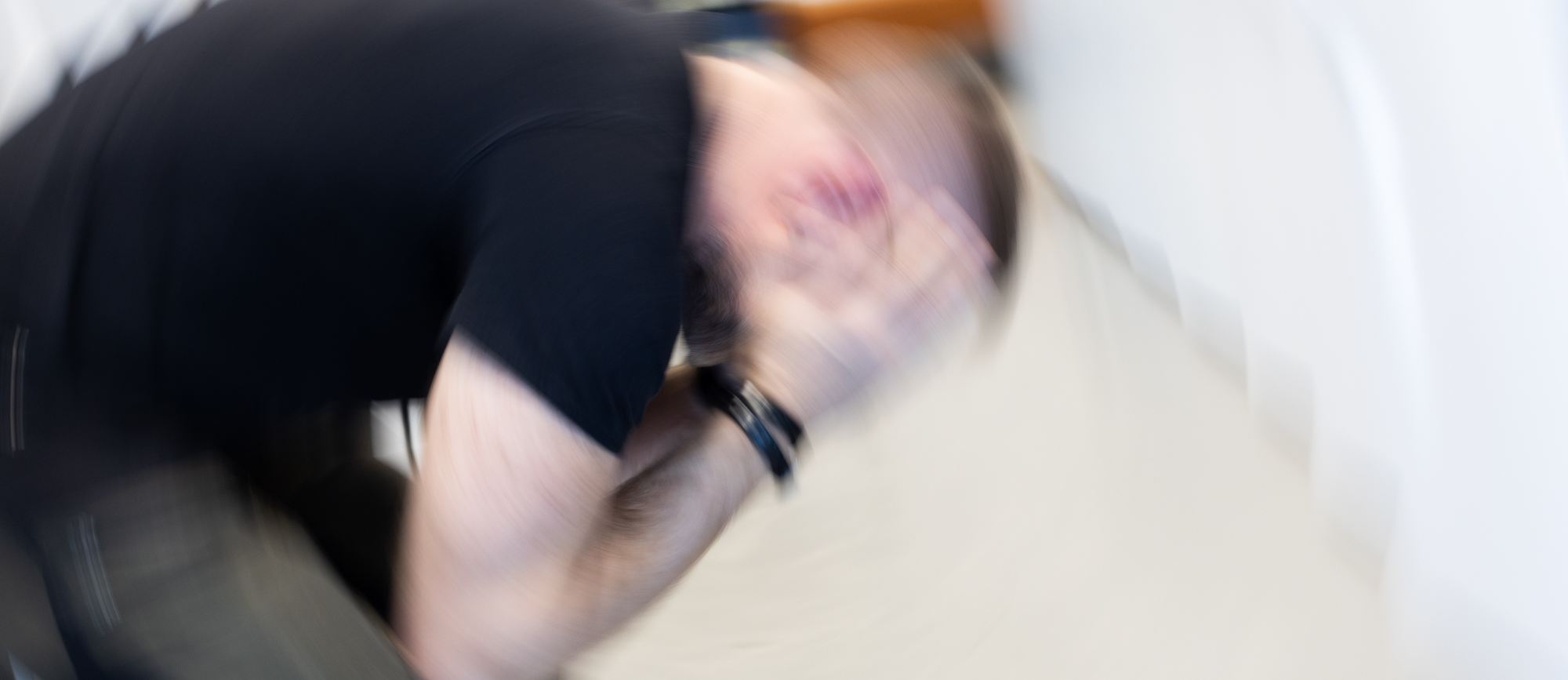 Suddig bild av person med huvudet i händerna. 