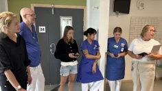 Vårdpersonal står i en korridor och samspråkar.