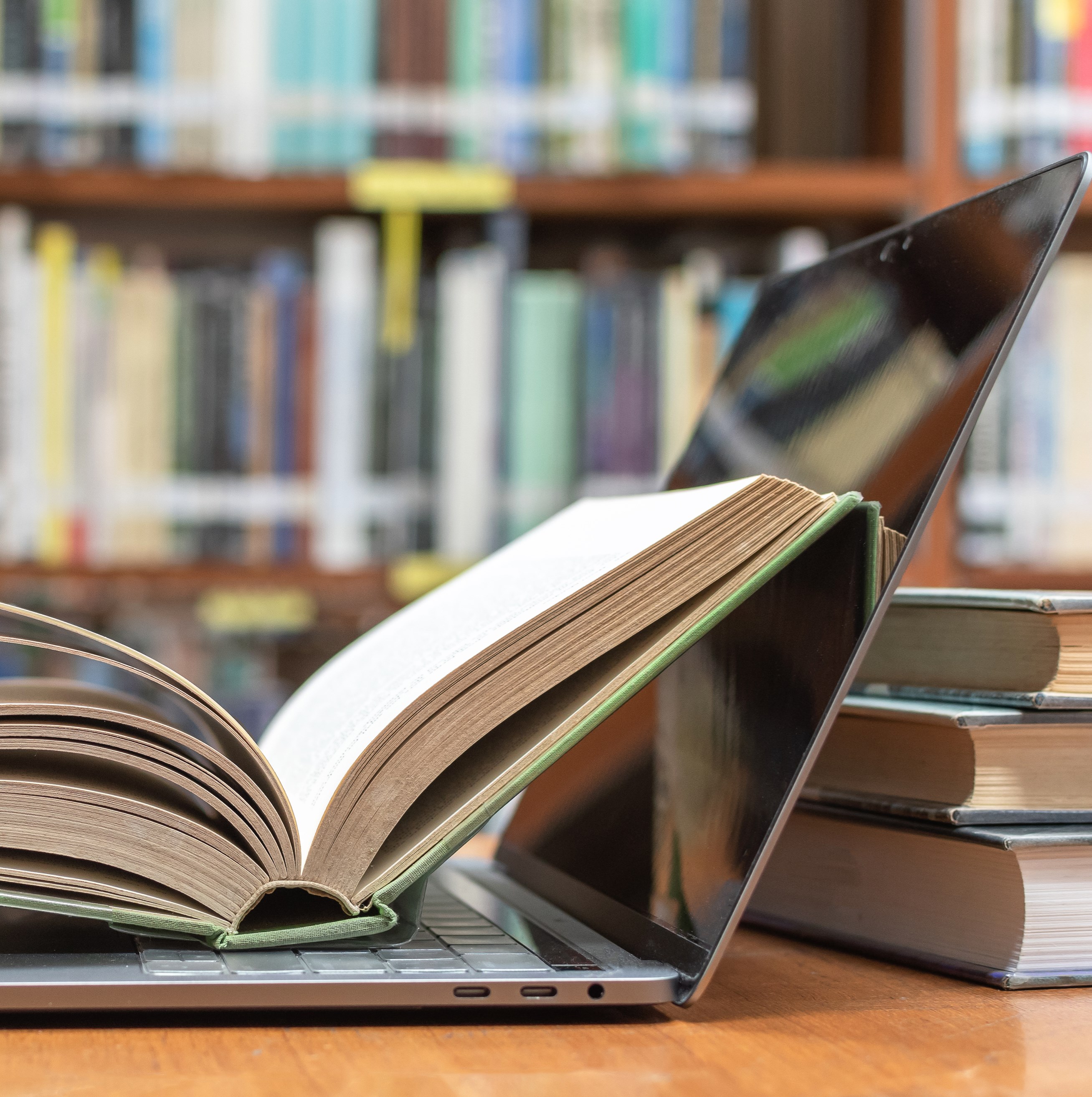 Bok ligger uppslagen på en laptop