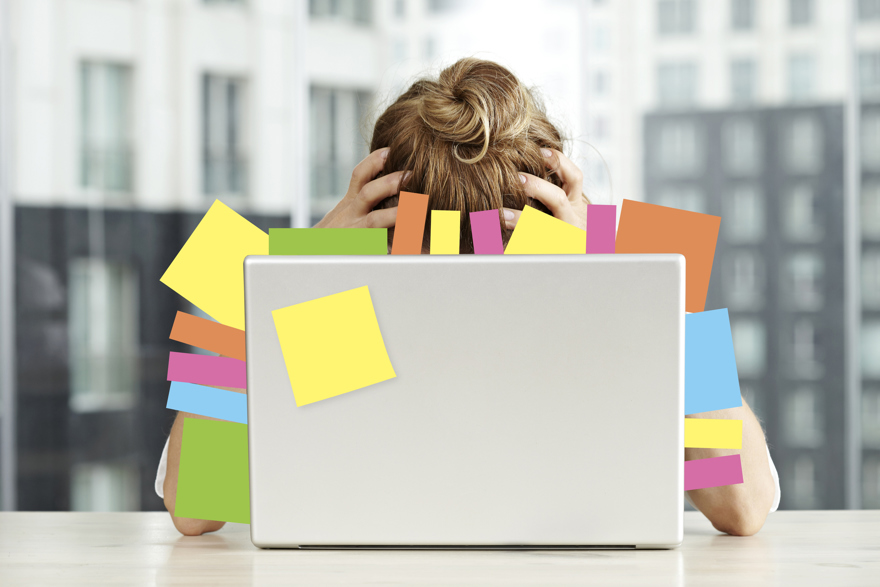 Stressad person dold bakom bildskärm