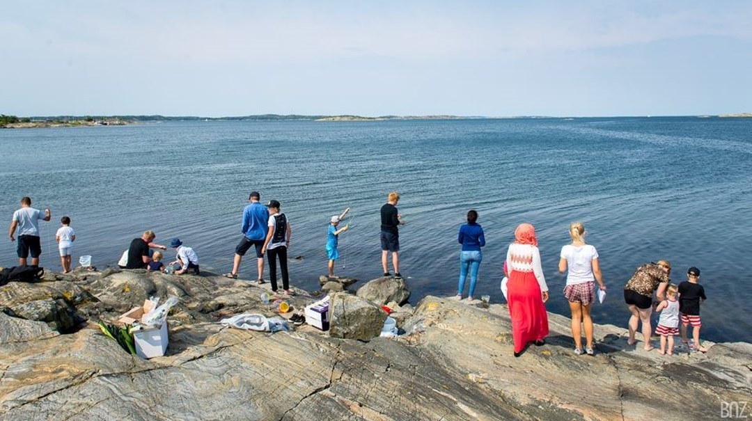 En grupp människor prövar sportfiske vid kusten