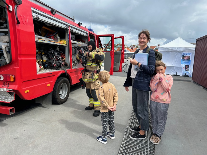 vrandbil med brandman och besökare