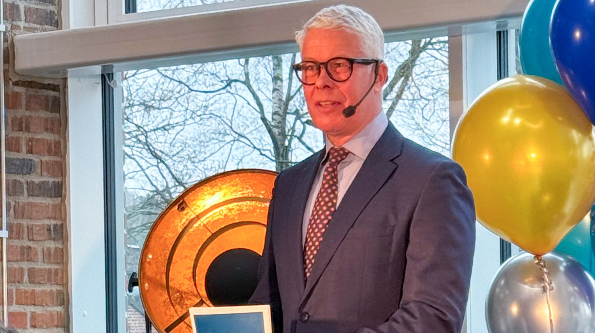 Man står vid pulpet och talar. Han håller i talarkort