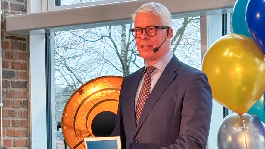 Man står vid pulpet och talar. Han håller i talarkort