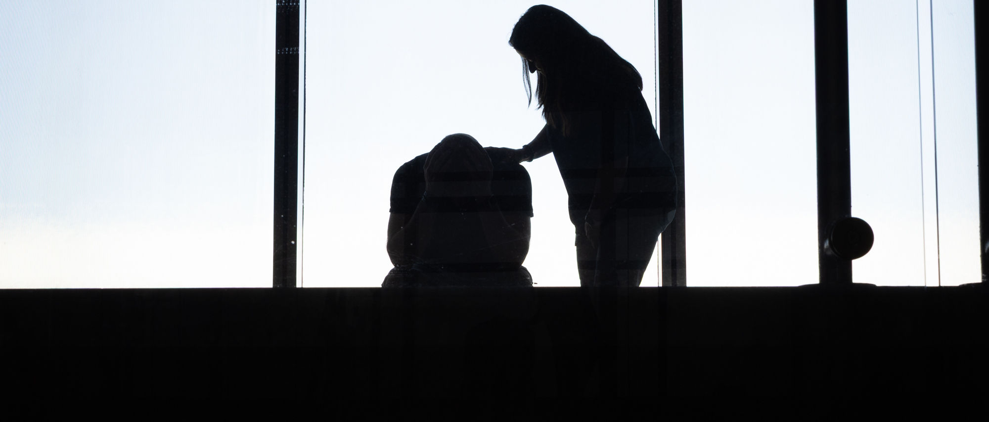 Siluett av kvinna som tröstar man.