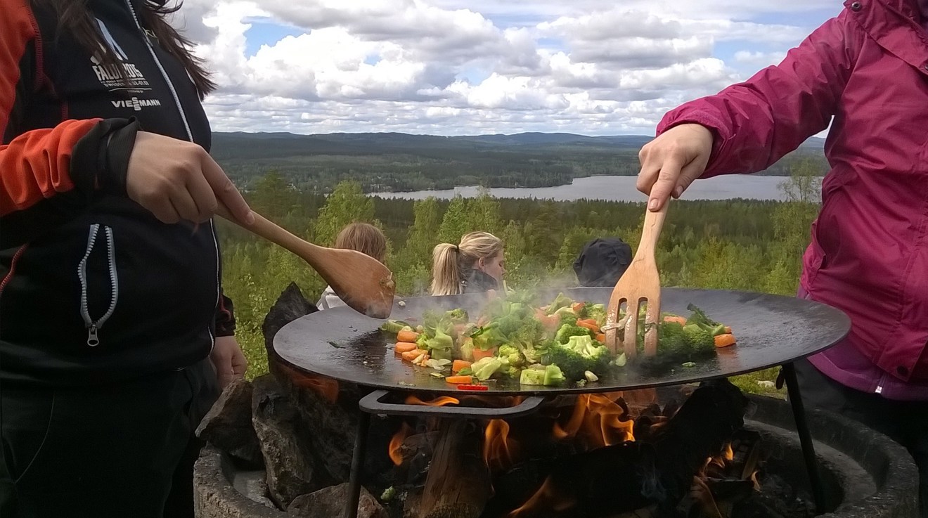 Mat wokas utomhus i vacker skogsmiljö