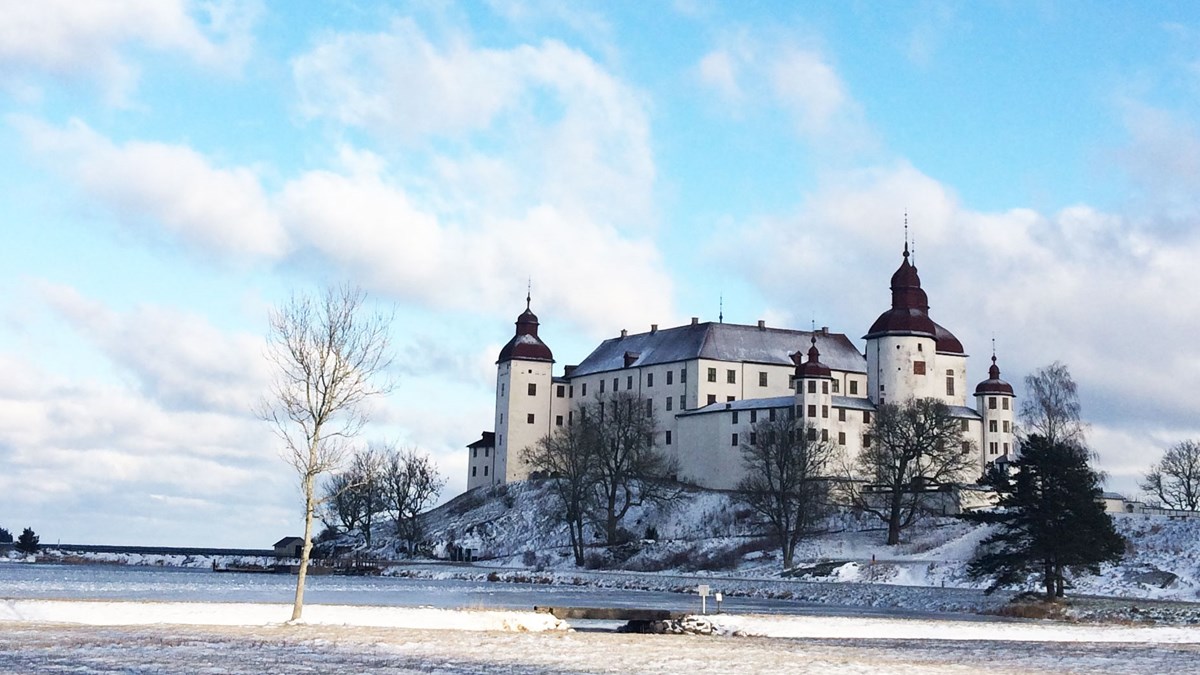 Bild på Läckö slott i vinterskrud. En vit byggnad med svart tak.