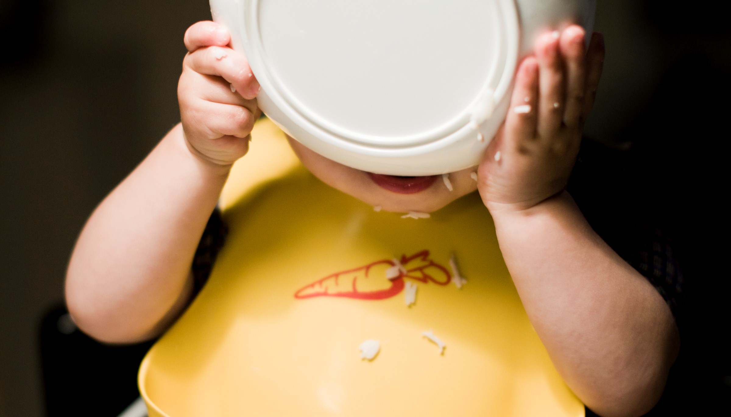 Pojke med tallrik framför ansiktet