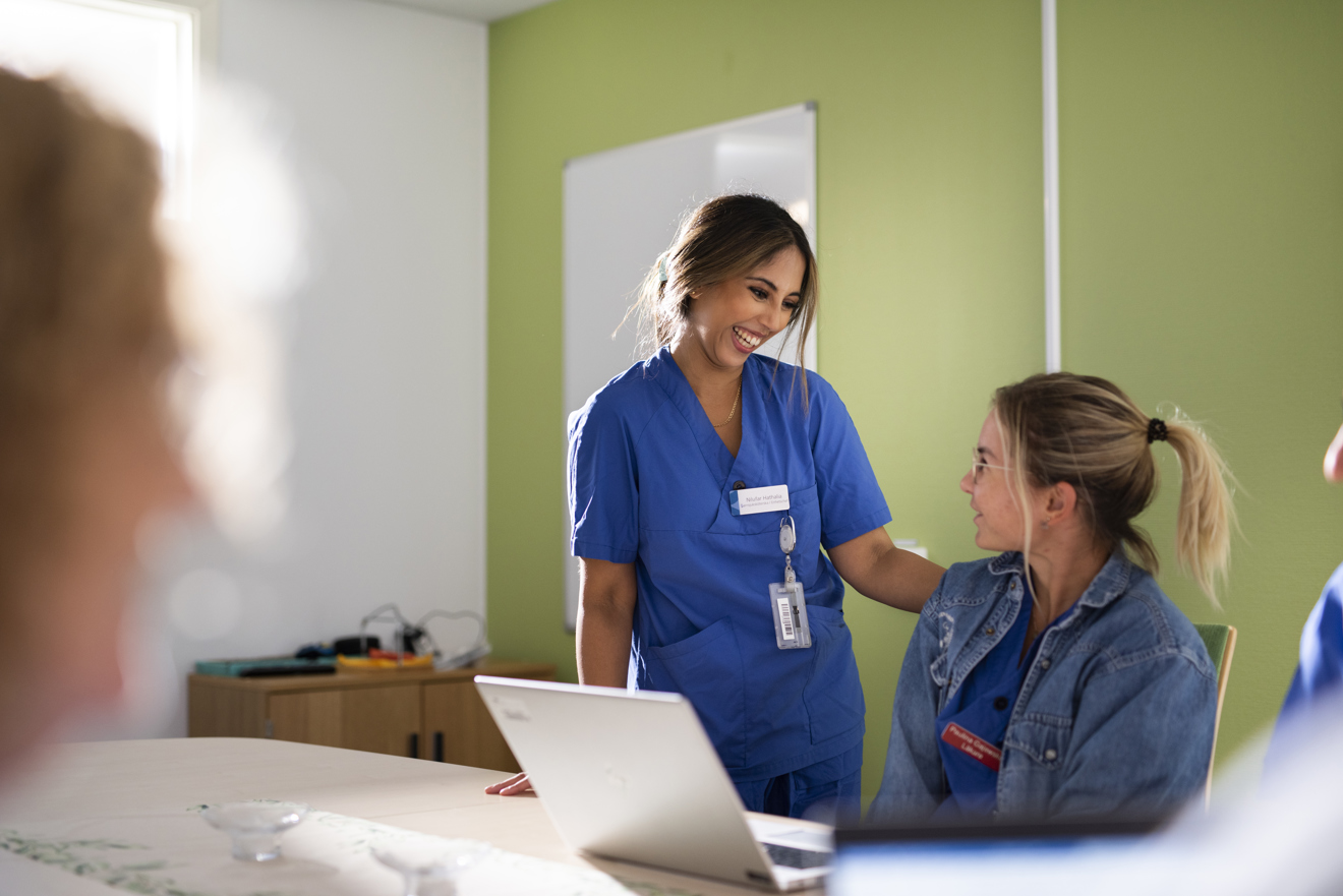 En leende chef står bredvid en glad medarbetare