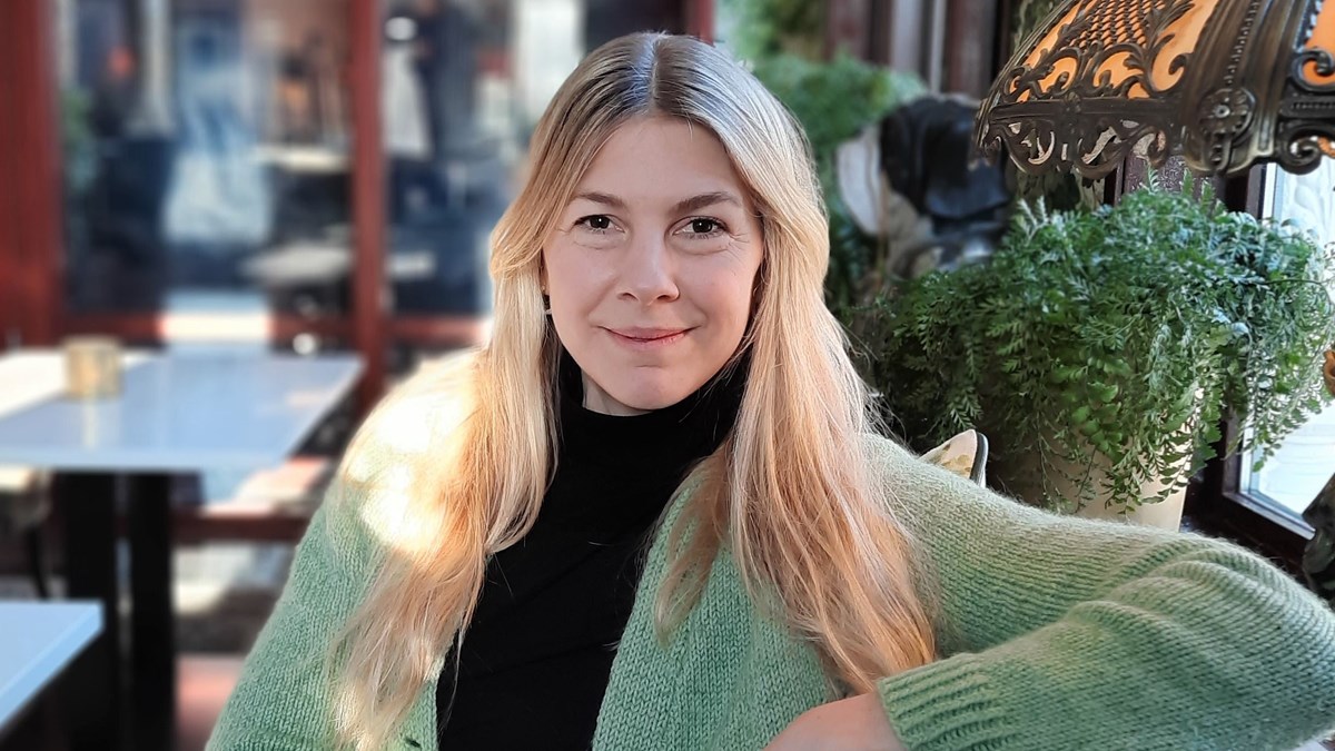 Sofia Hammarström sitter i restaurangmiljö, porträttfoto