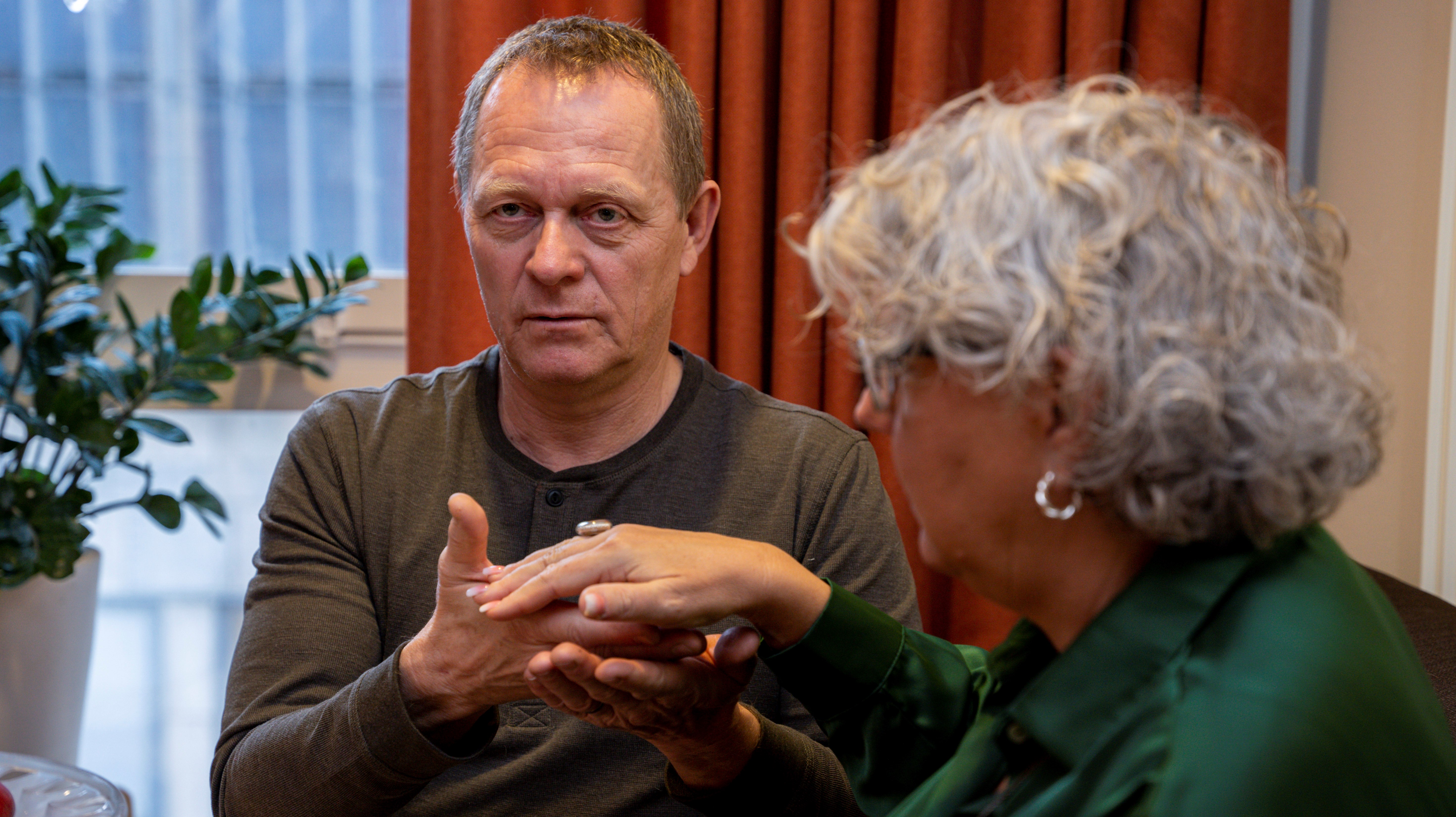 Två personer vars händer rör varandra i taktil tolkning. 