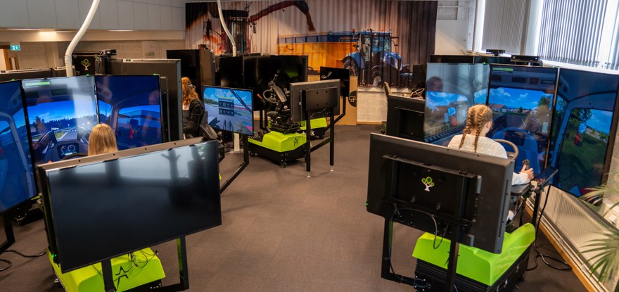 Elever sitter i simulatorer med skärmar och kör olika slags maskiner