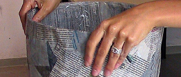 Två händer formar en påse av papper