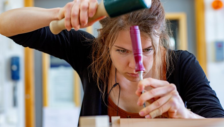 Koncentrerad ung tjej som hugger med stämjärn