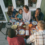 Olika generationer som äter på verandan.