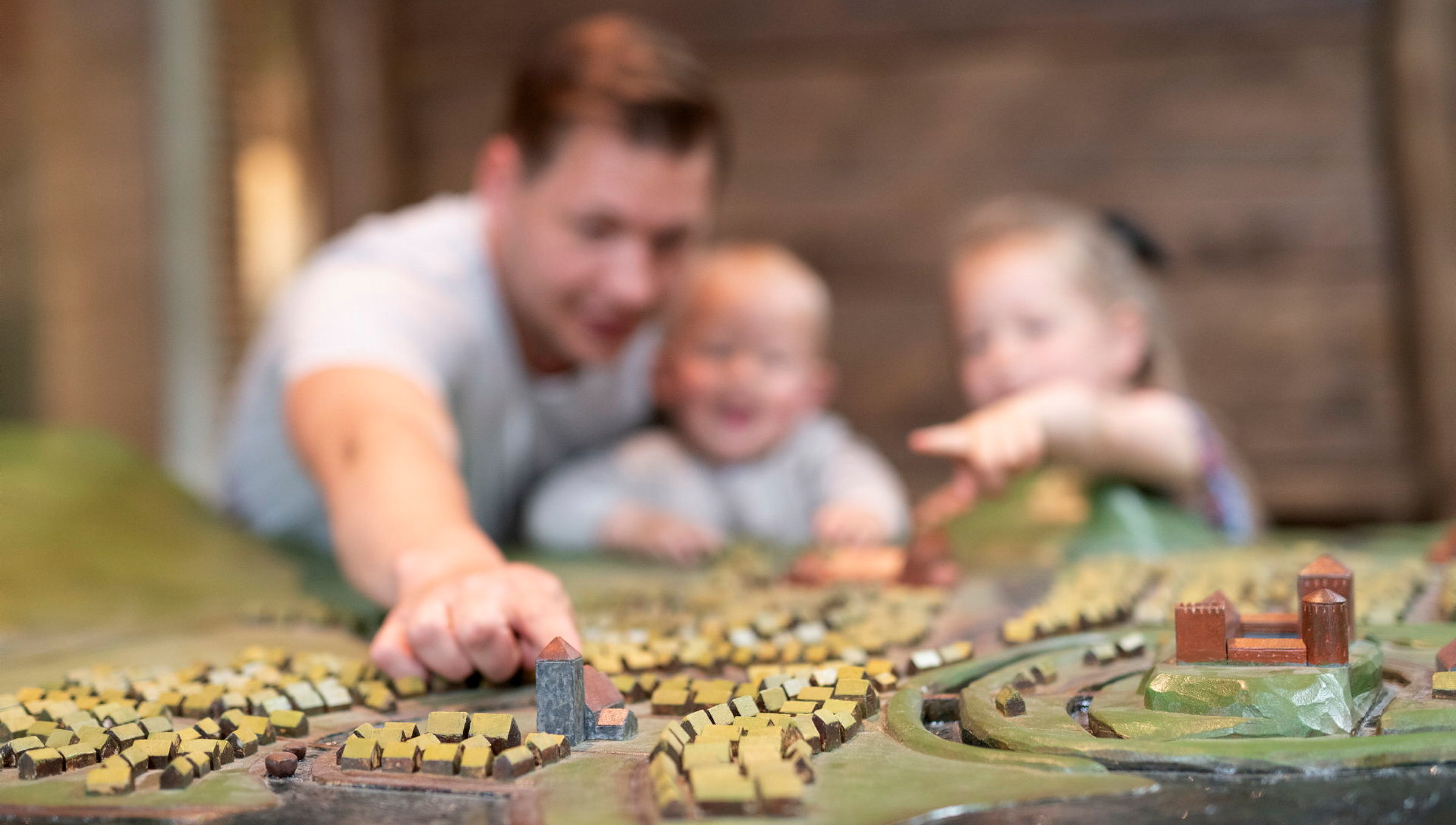 family watches model of old town