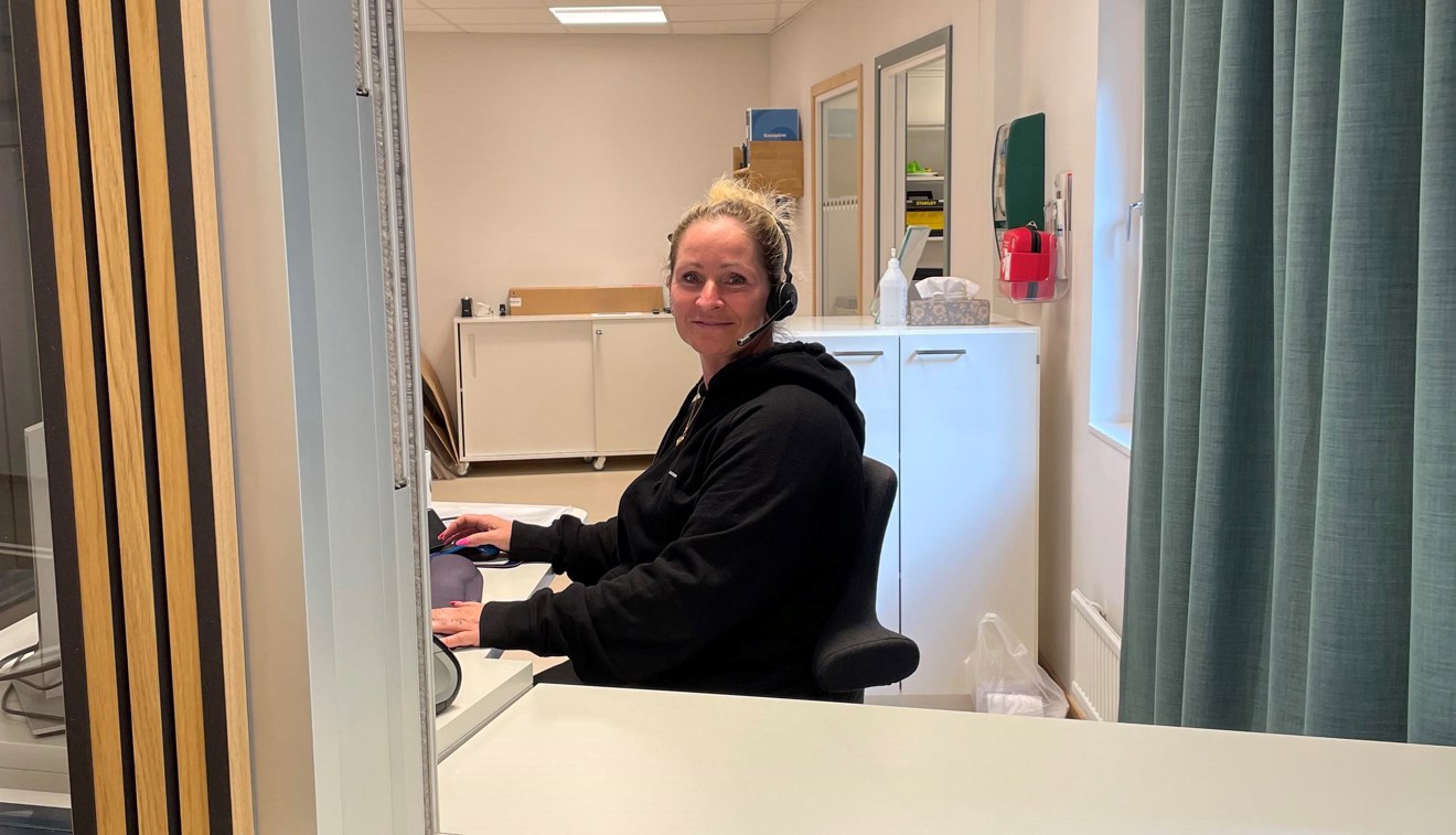 Receptionslucka med leende personal bakom.