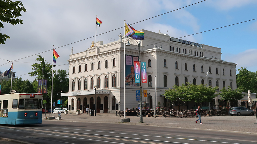 Ett stort vitt hus omgivet av gröna träd.