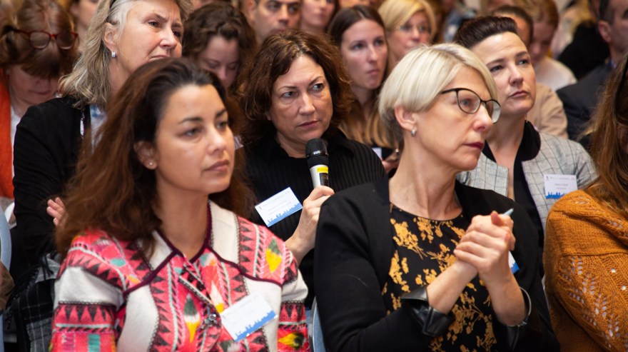 en kvinna sitter med mikrofon mitt i en fullsatt biosittning