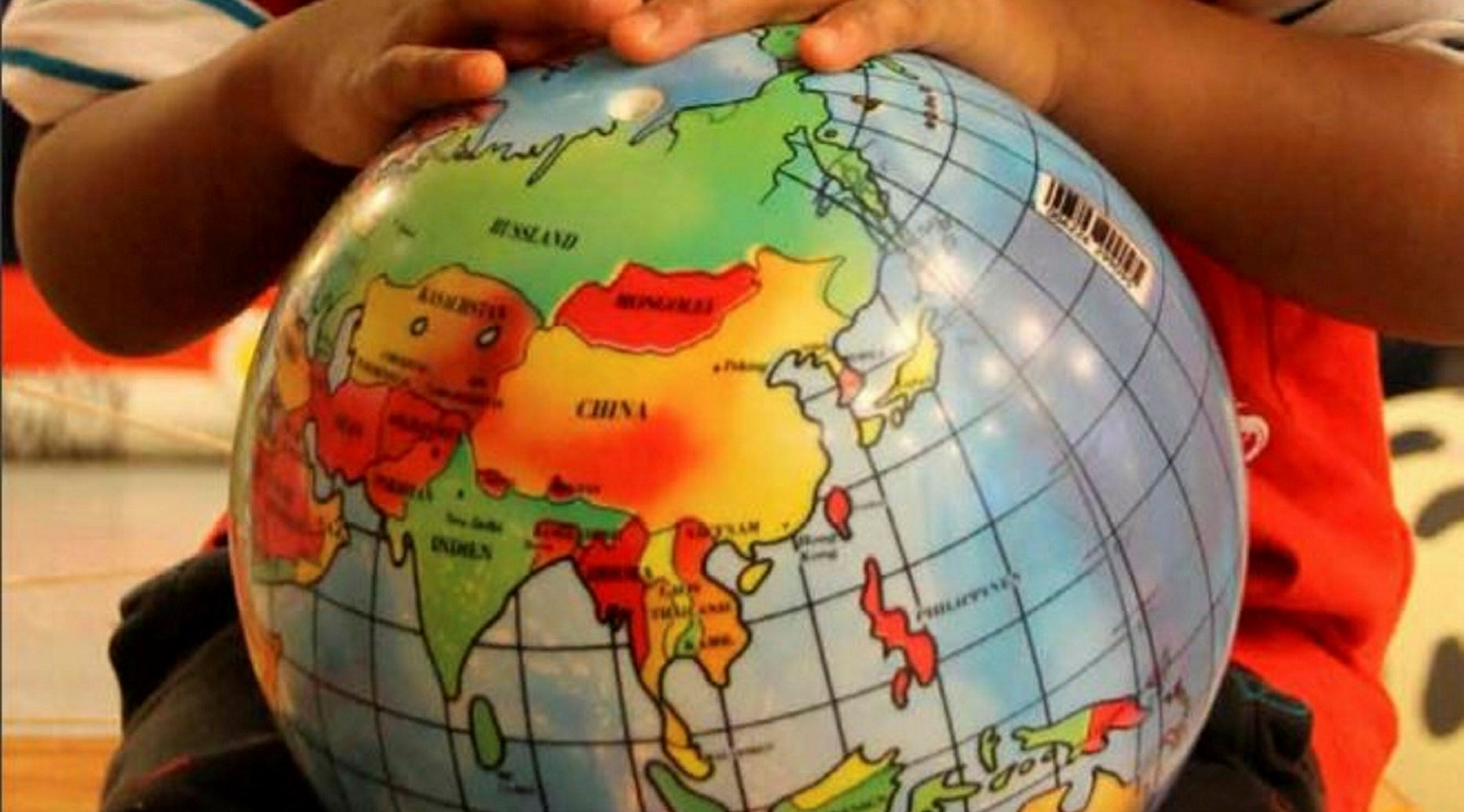 Framsida på en rapport där ett barn håller en jordglob