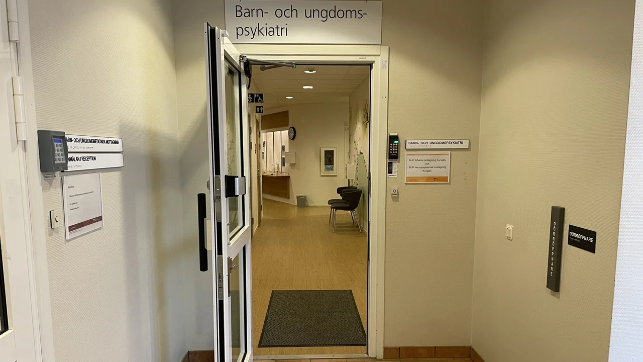 En öppen dörr. Ovanför hänger en skylt där det står "Barn- och ungdomspsykiatri"
