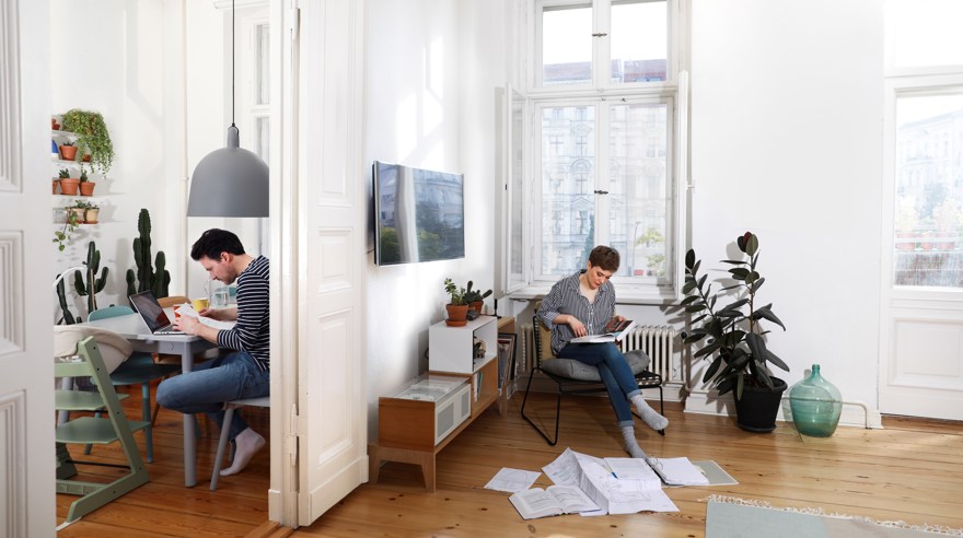 Två personer kontorsarbetar i var sitt rum hemma