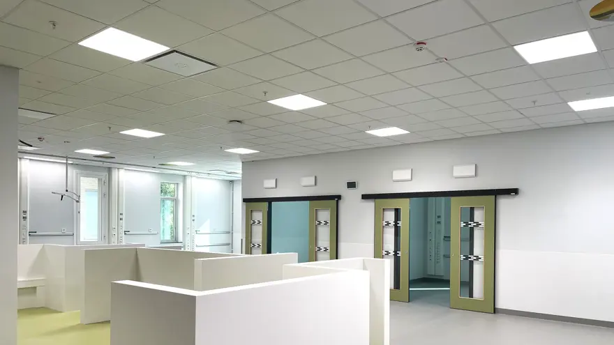 Uppvakningssal med grått golv som övergår i limegrönt, och vita väggar.