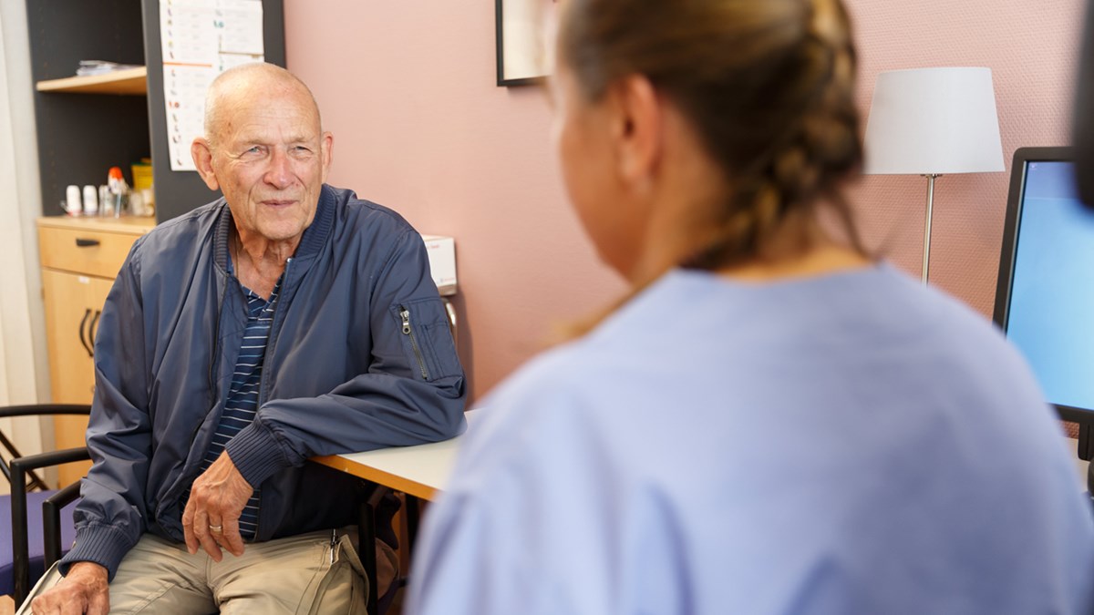 Patientmöte mellan en äldre man och en kvinnlig vårdpersonal