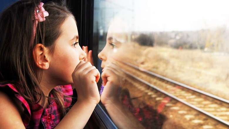 Flicka åker tåg och tittar på utsikten