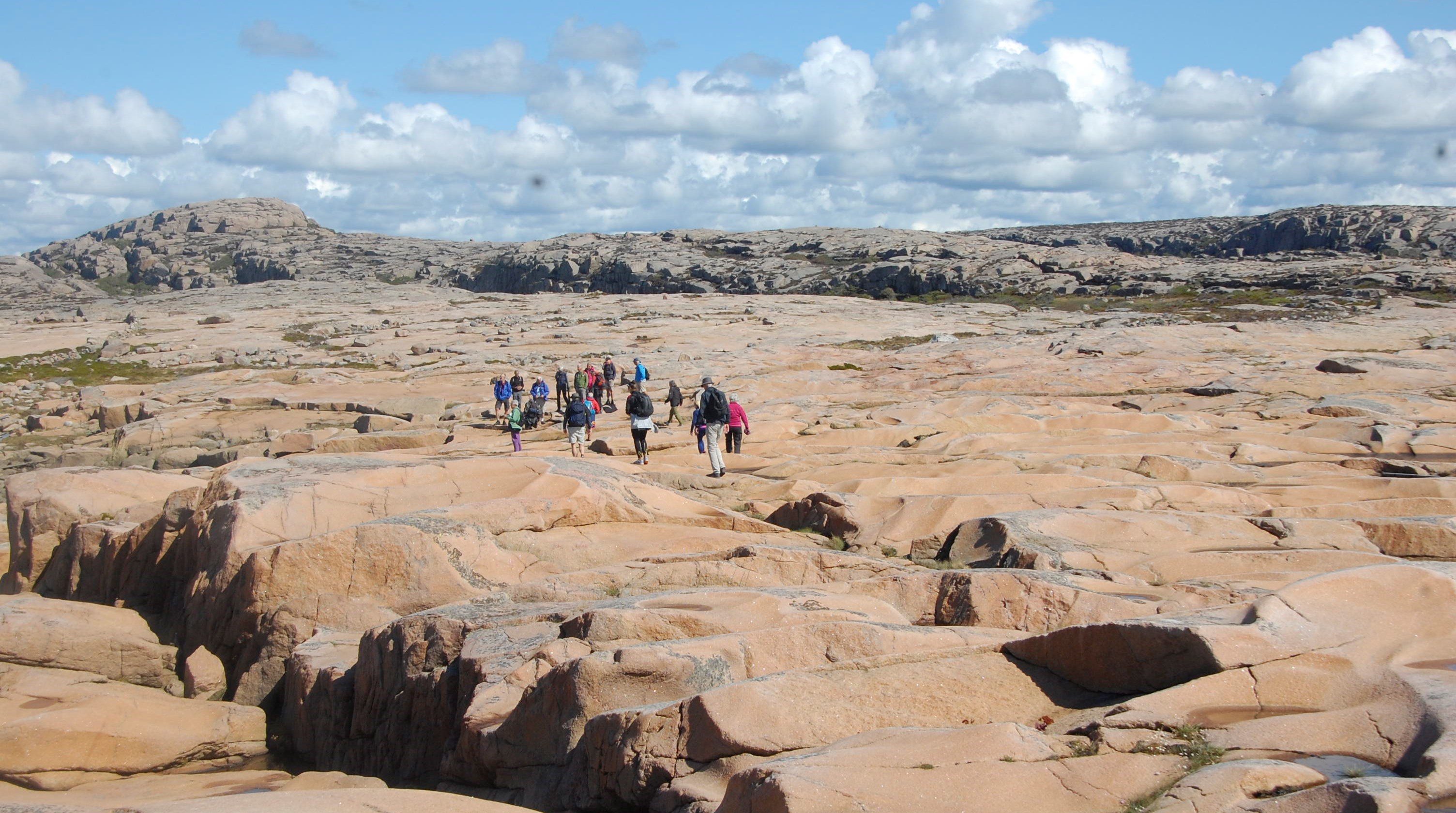 En grupp människor vandrar på rosa klippor