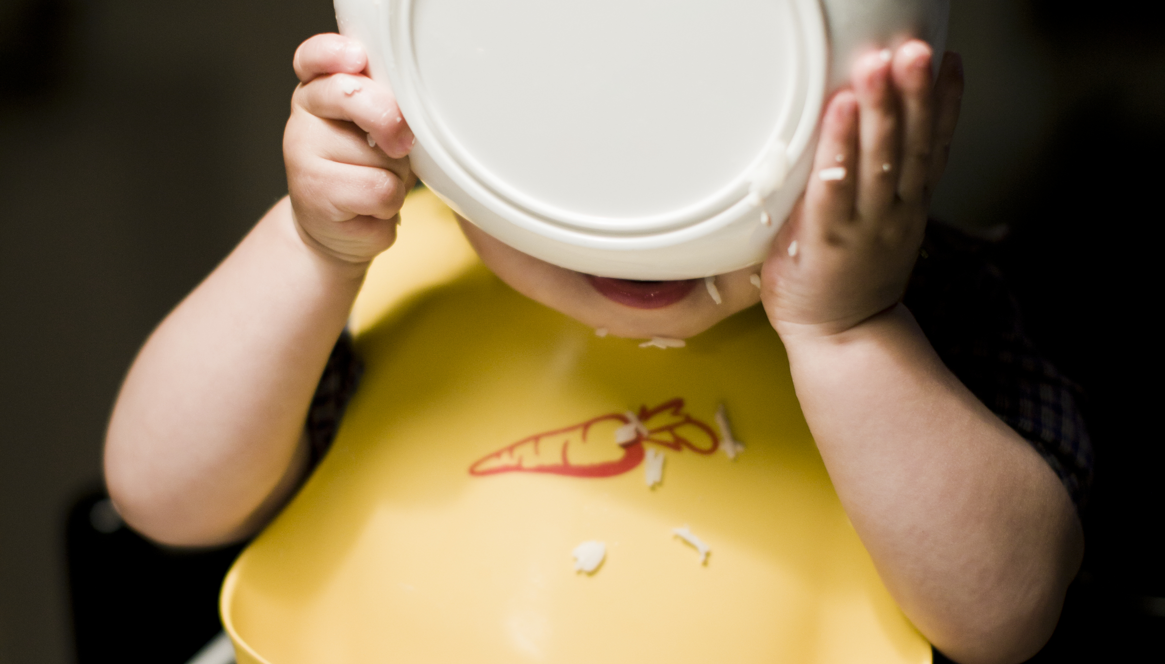 Pojke med tallrik framför ansiktet