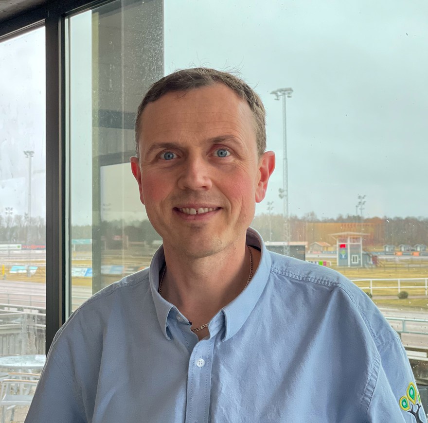Foto på Kent Karlsson med Axevalla travbana i bakgrunden