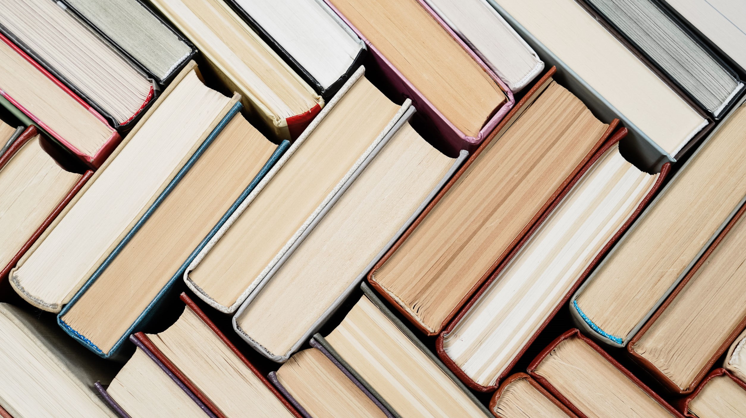 Many Books Piles. Hardback books on wooden table. Back to school. Copy space