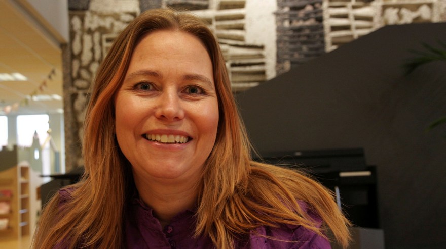 Maria Nordin har blont långt rakt hår och är klädd i en lila blus. Hon ler mot kameran.