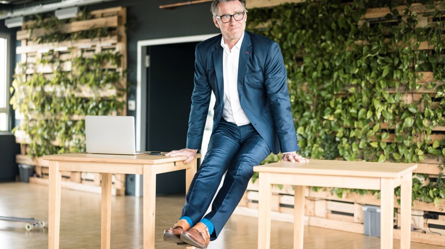 En man i kostym gör rörelser på kontoret