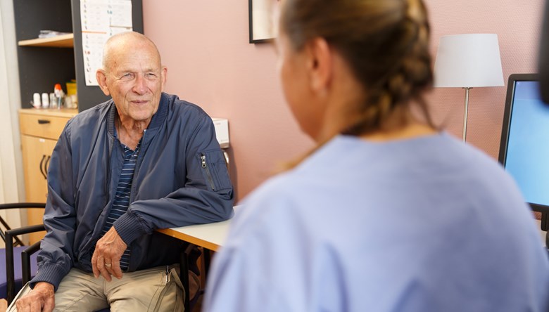 Patientmöte mellan en äldre man och en kvinnlig vårdpersonal