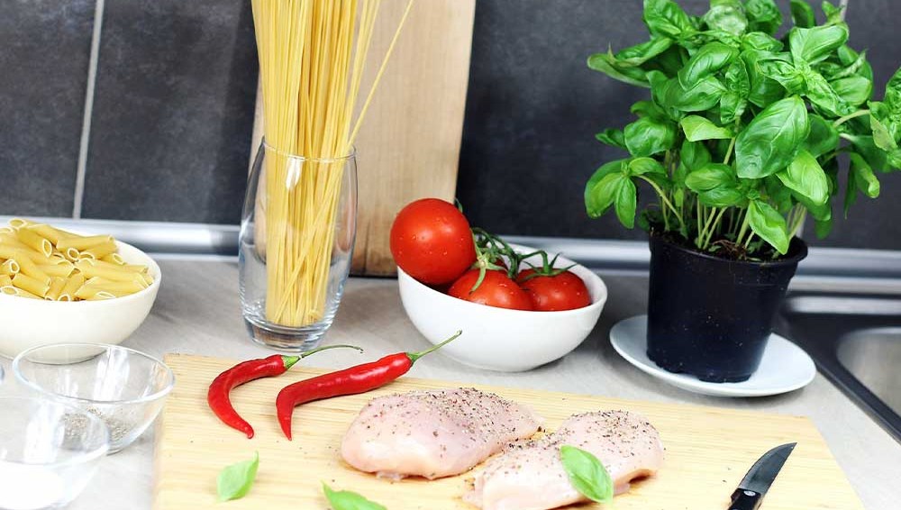 Pasta och kyckling förbereds inför måltid