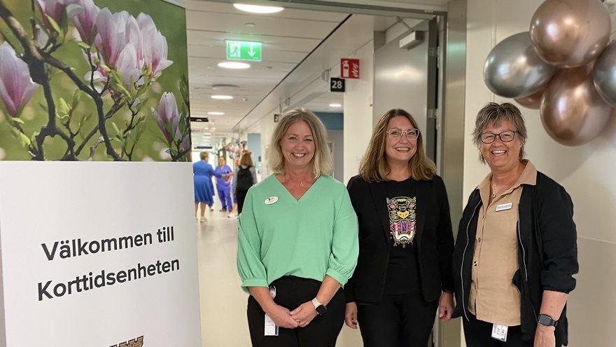 Tre leende kvinnor vid skylt som säger: Välkommen till Korttidsenheten, Kungälvs kommun.