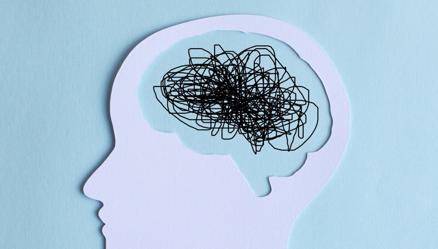 Paper cut out of a human head with a chaotic line drawing for a brain