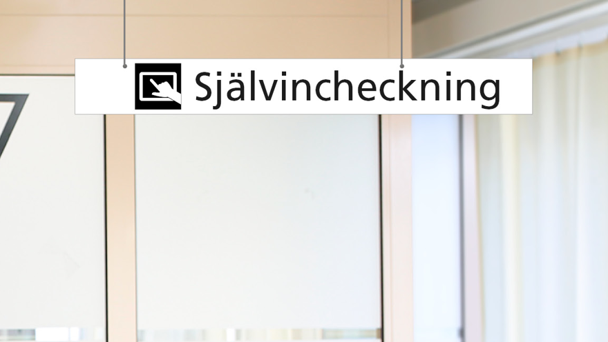 Närbild av takskylt för självincheckning med pictogram och utrymme för eventuell pil.