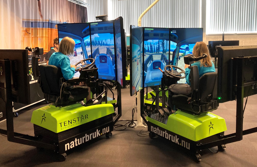 Två tjejer sitter vid var sin simulator för att öva.