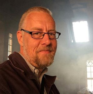 Björn Ohlén tittar mot kameran med ljus från flera fönster bakom sig.