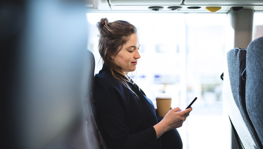 Gravid kvinna som tittar på mobilen