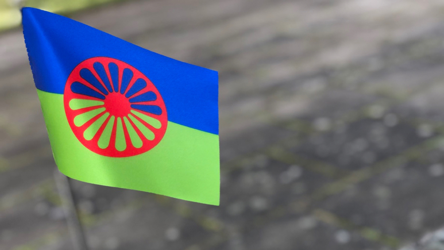 Den romska flaggan, med grön och blå botten och ett rött hjul i mitten.