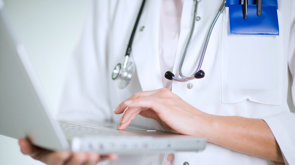 händer som håller i en dator