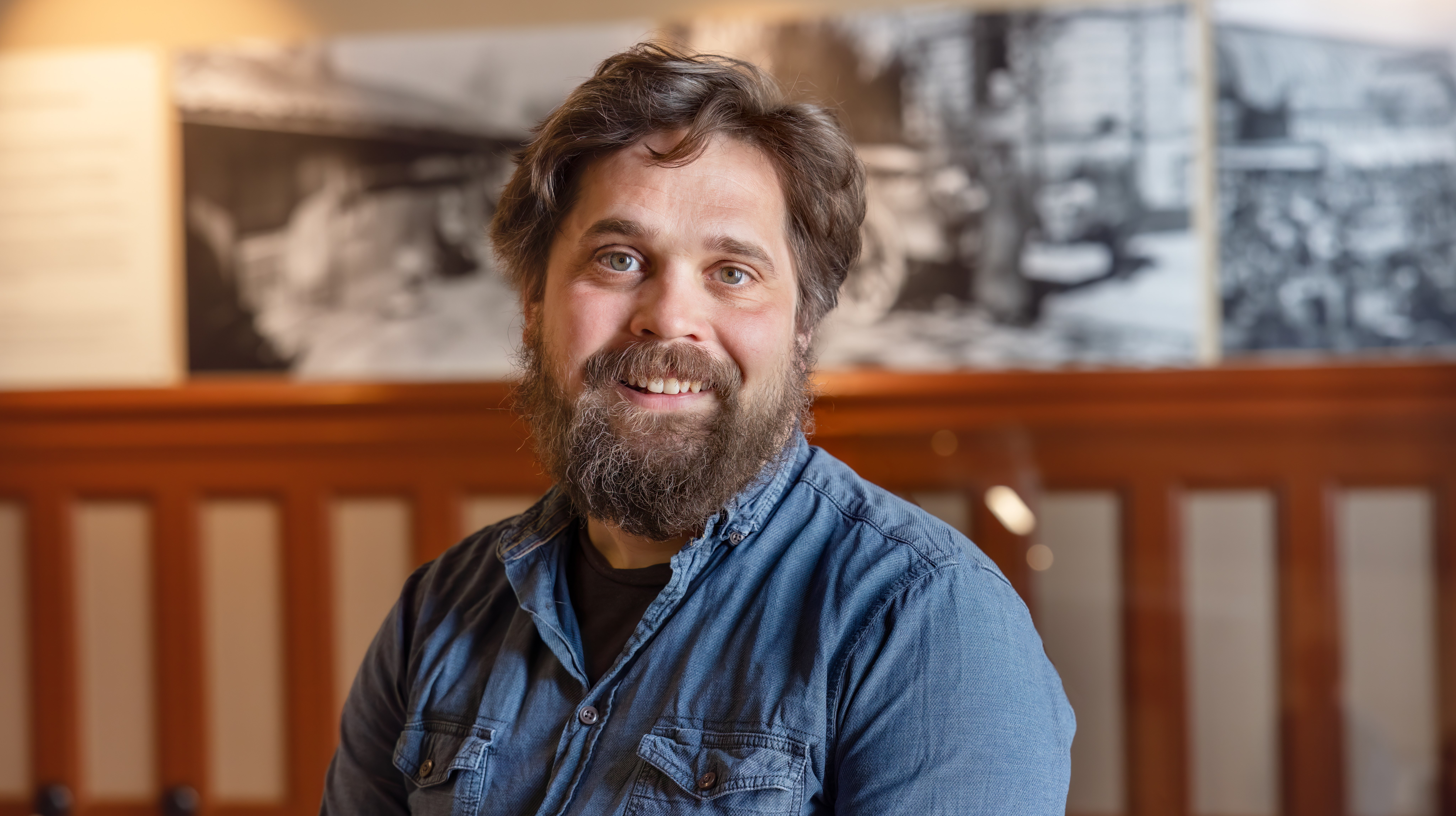 man, brunt kort hår, brunt skägg och mustasch. Jeansskjorta